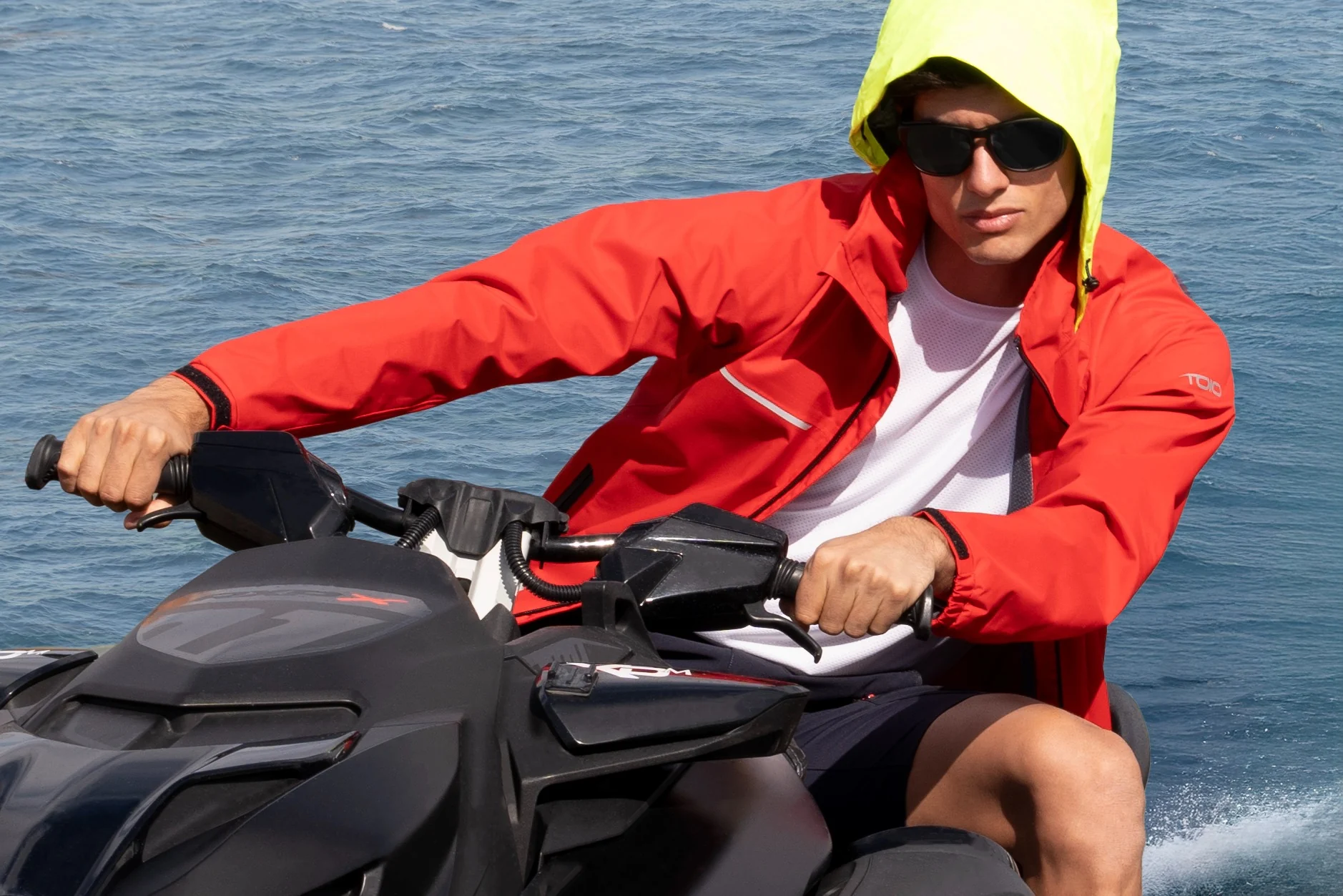 Male model in a red sailing jacket on a jet ski
