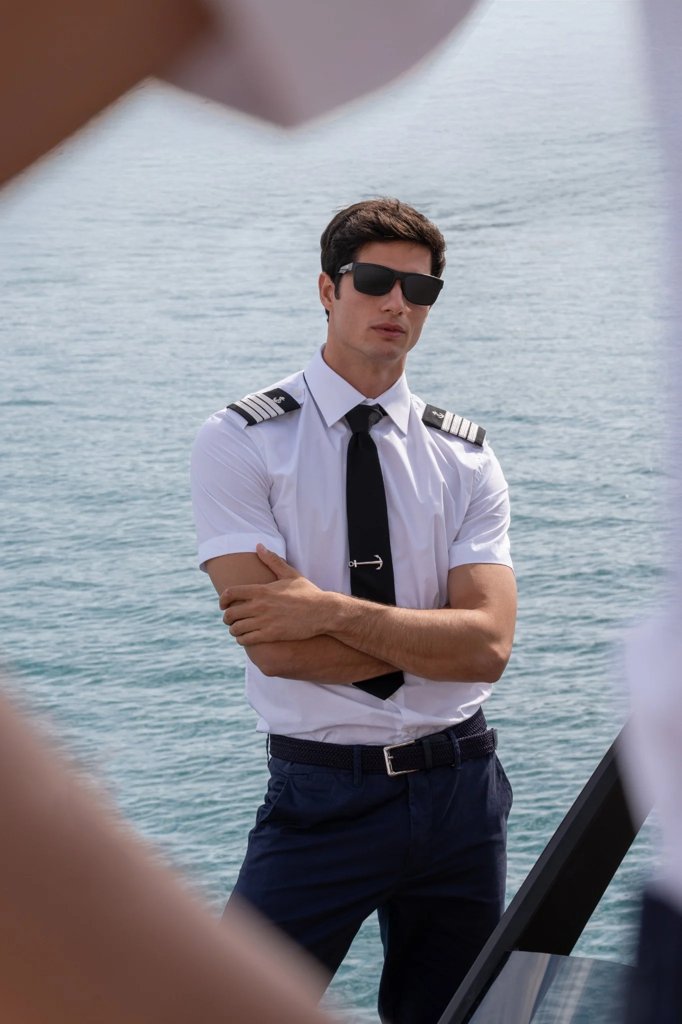 Male model in a white captain’s shirt framed by yacht details