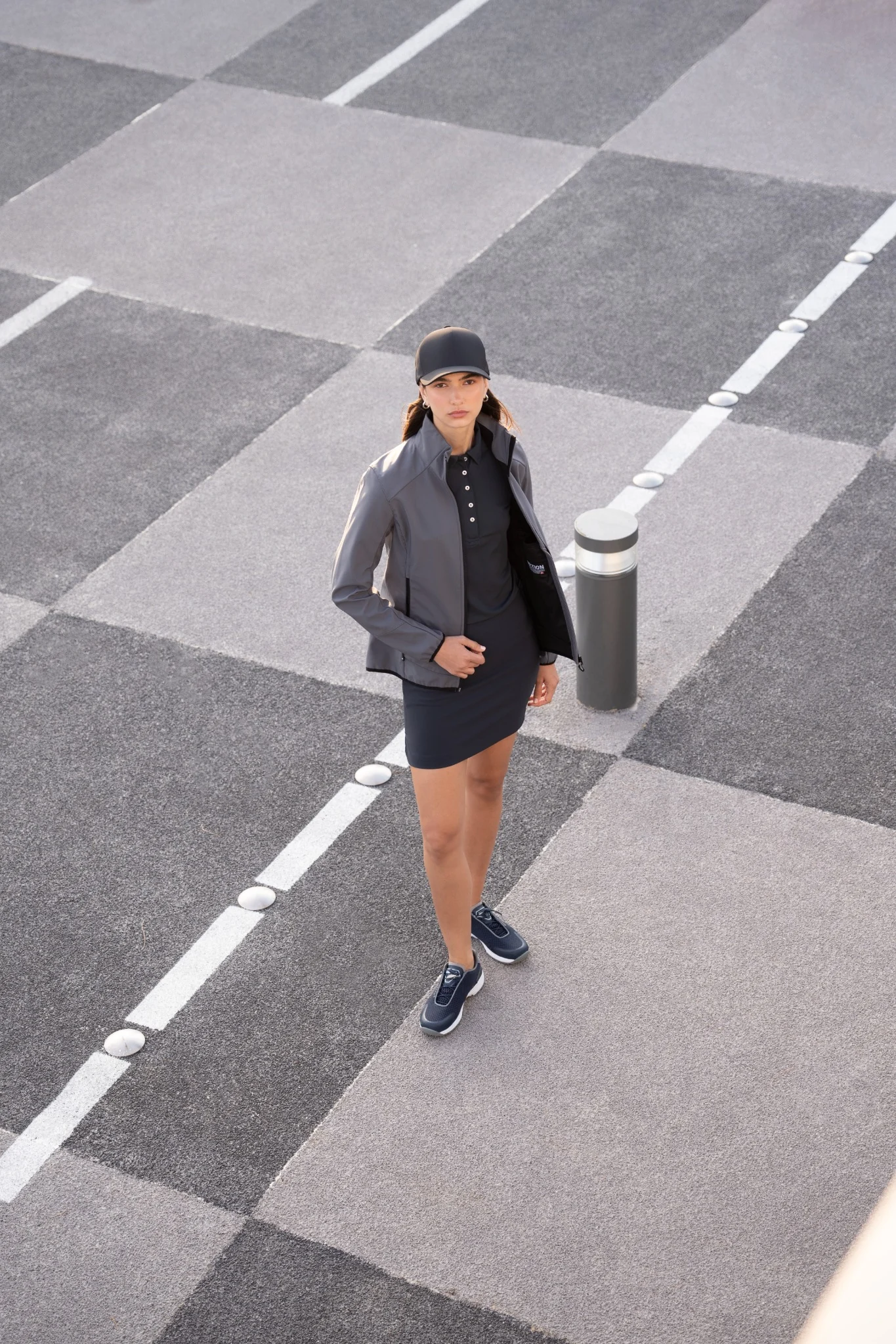 Overhead portrait of a female model on a geometric paved walkway