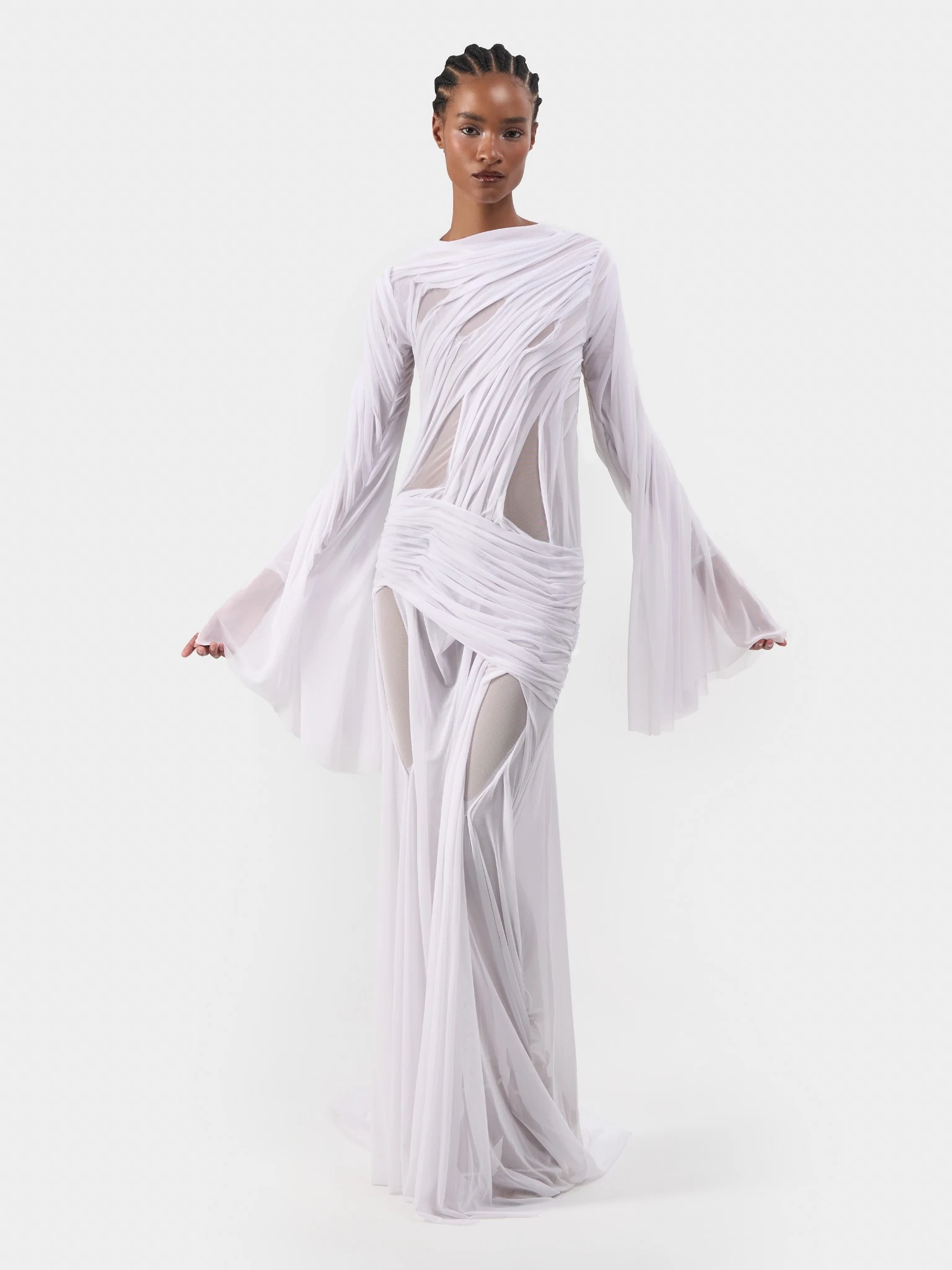 Full-length studio portrait in a draped white bridal gown with flowing sleeves