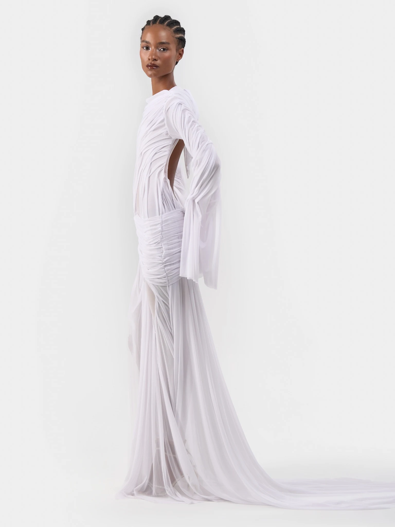 Side view of a draped white bridal gown and its long train