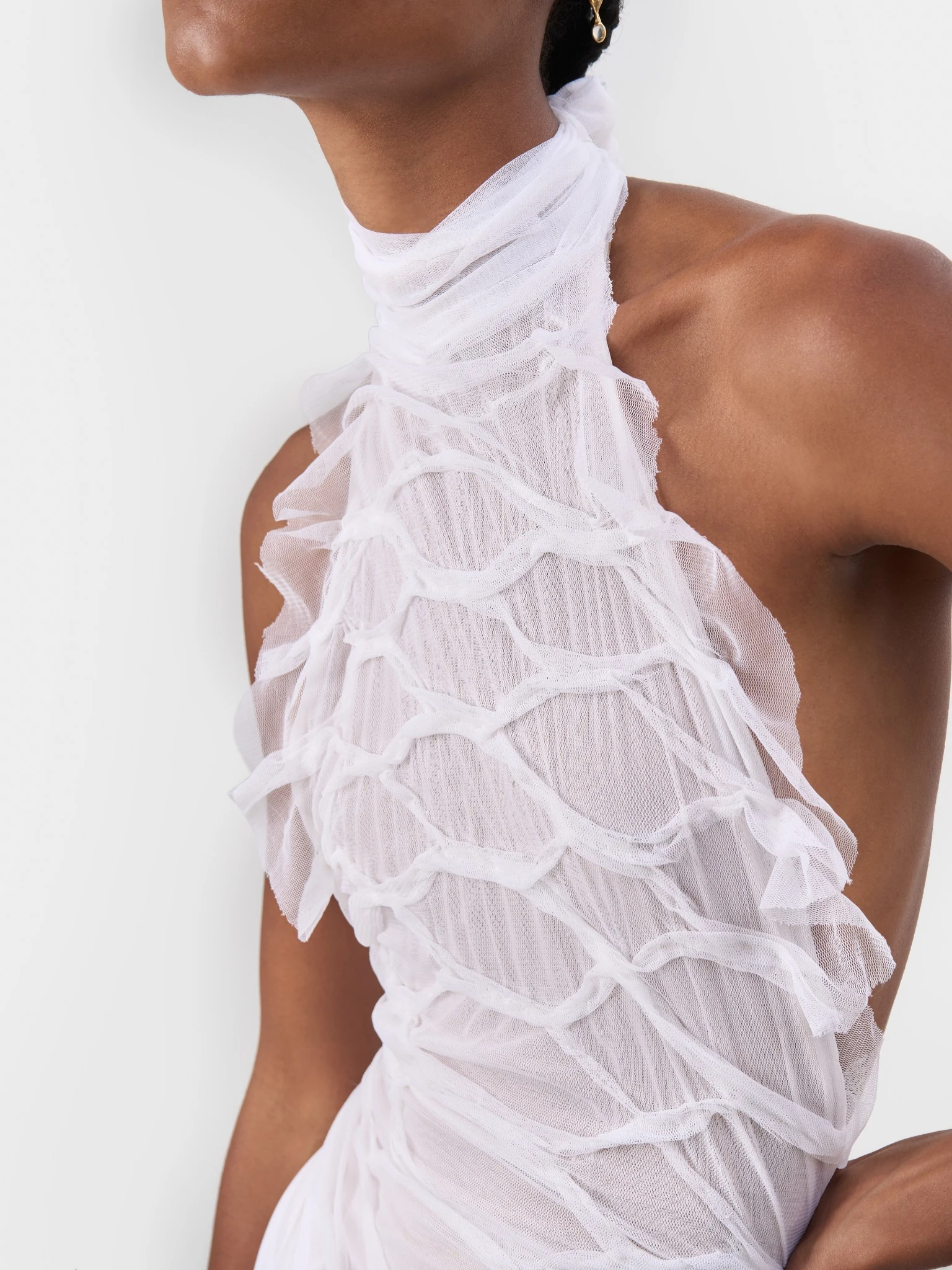 Close detail of the neckline and gathered fabric of a white bridal gown