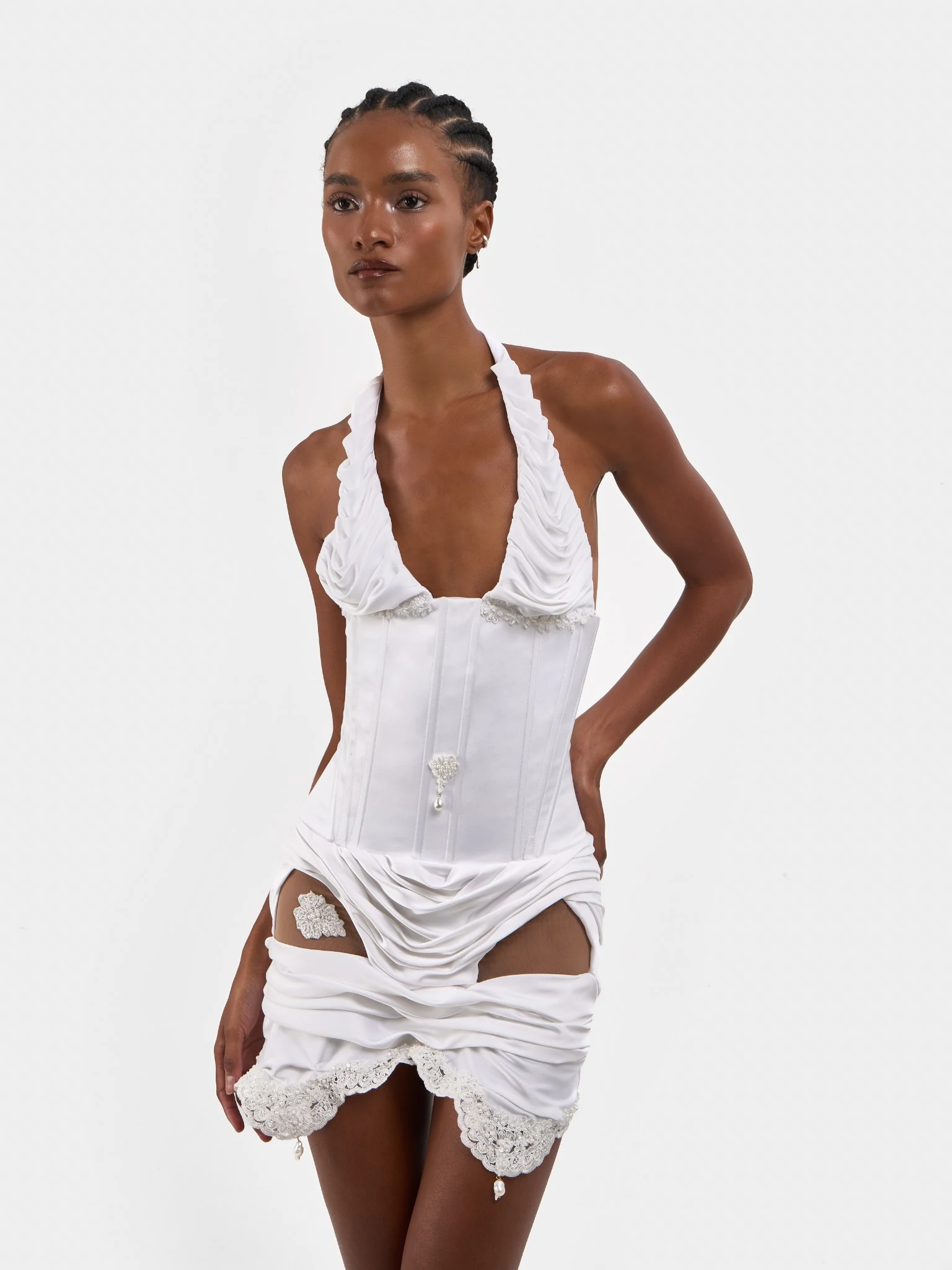 Model wearing a white bridal corset dress with lace and pearl details