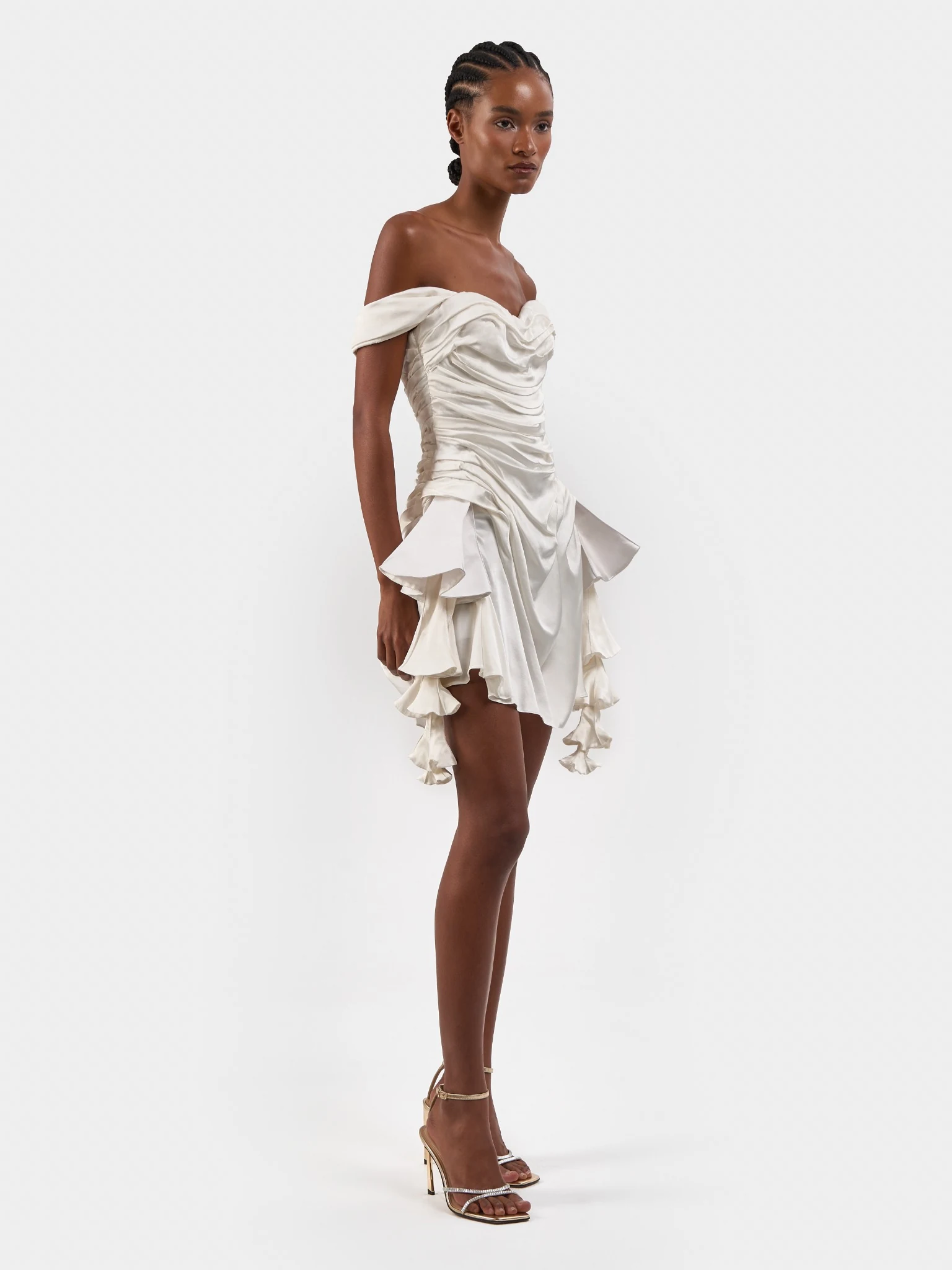 Full-length portrait in a short ivory bridal dress with a sculptural ruffled skirt