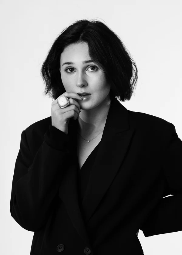 Expressive black-and-white portrait of a woman in a tailored black suit
