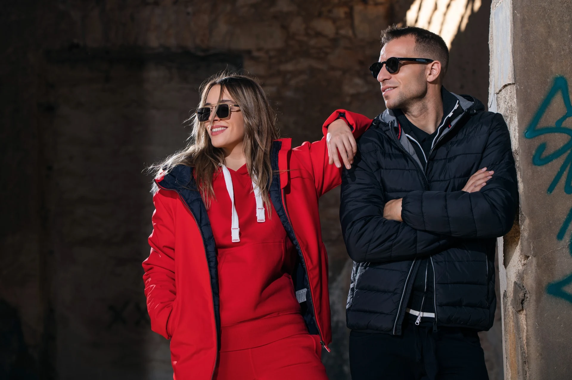 Two models in red and black Molossos outerwear beside a column at the former industrial site