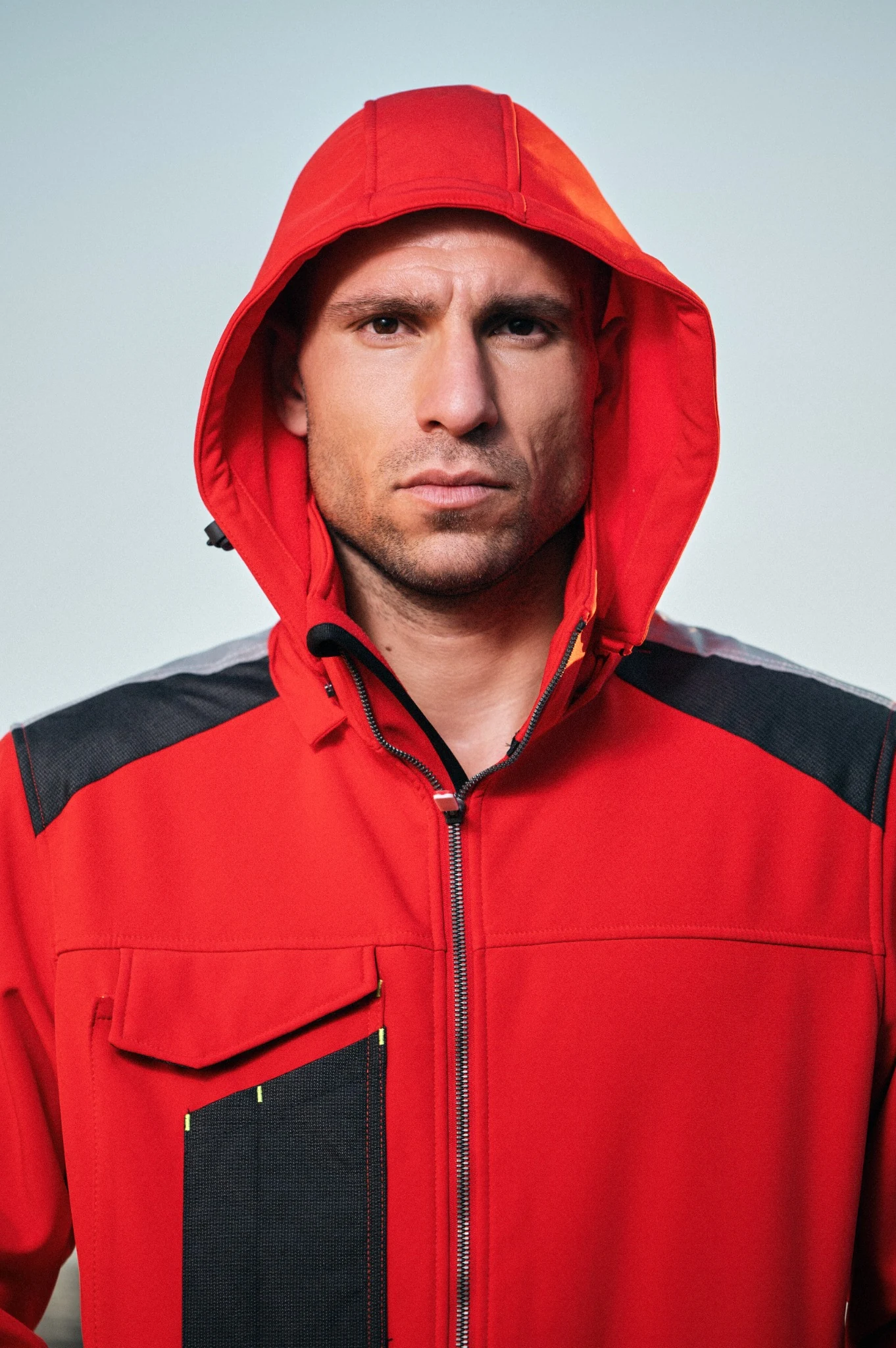 Close portrait of a model in a red hooded work jacket