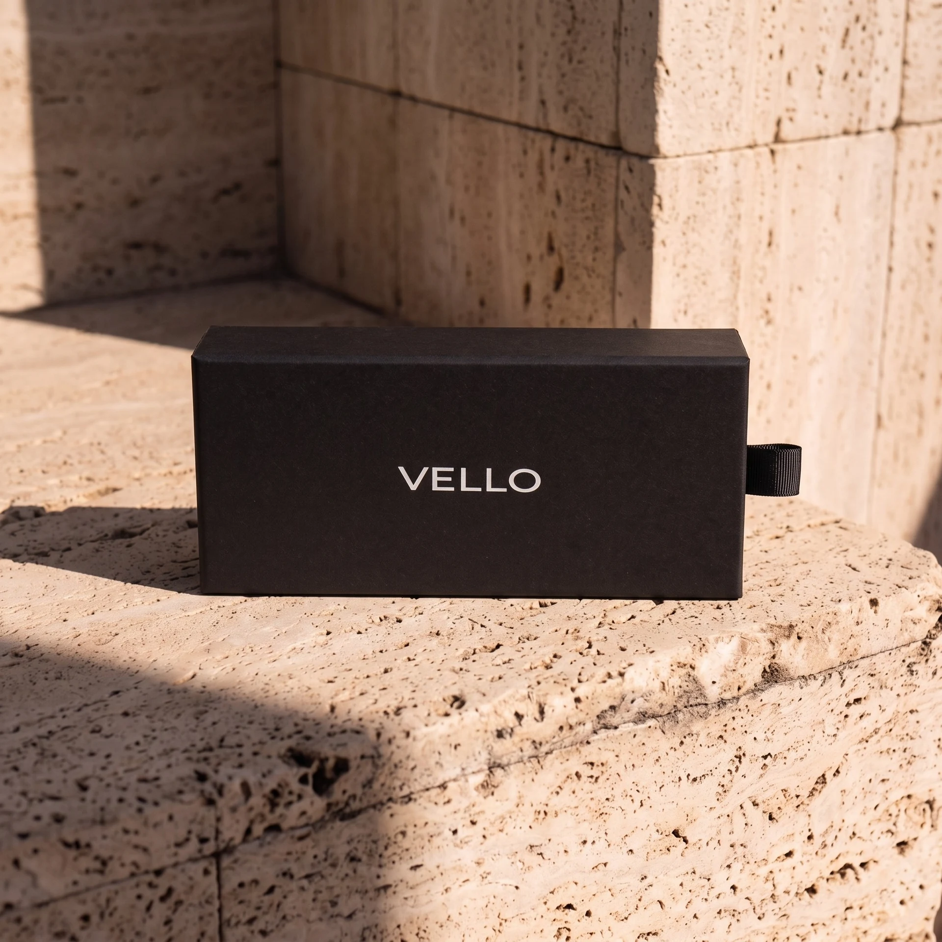 Black Vello presentation box on sunlit stone steps