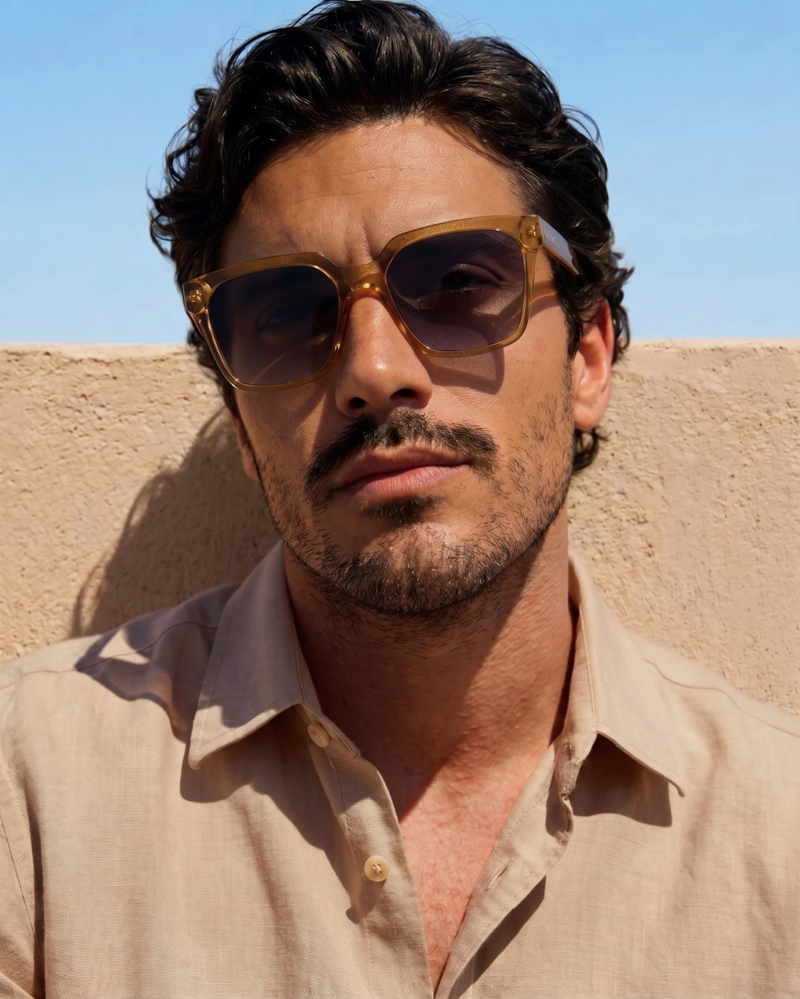 AI male model wearing amber Vello sunglasses beneath a blue sky