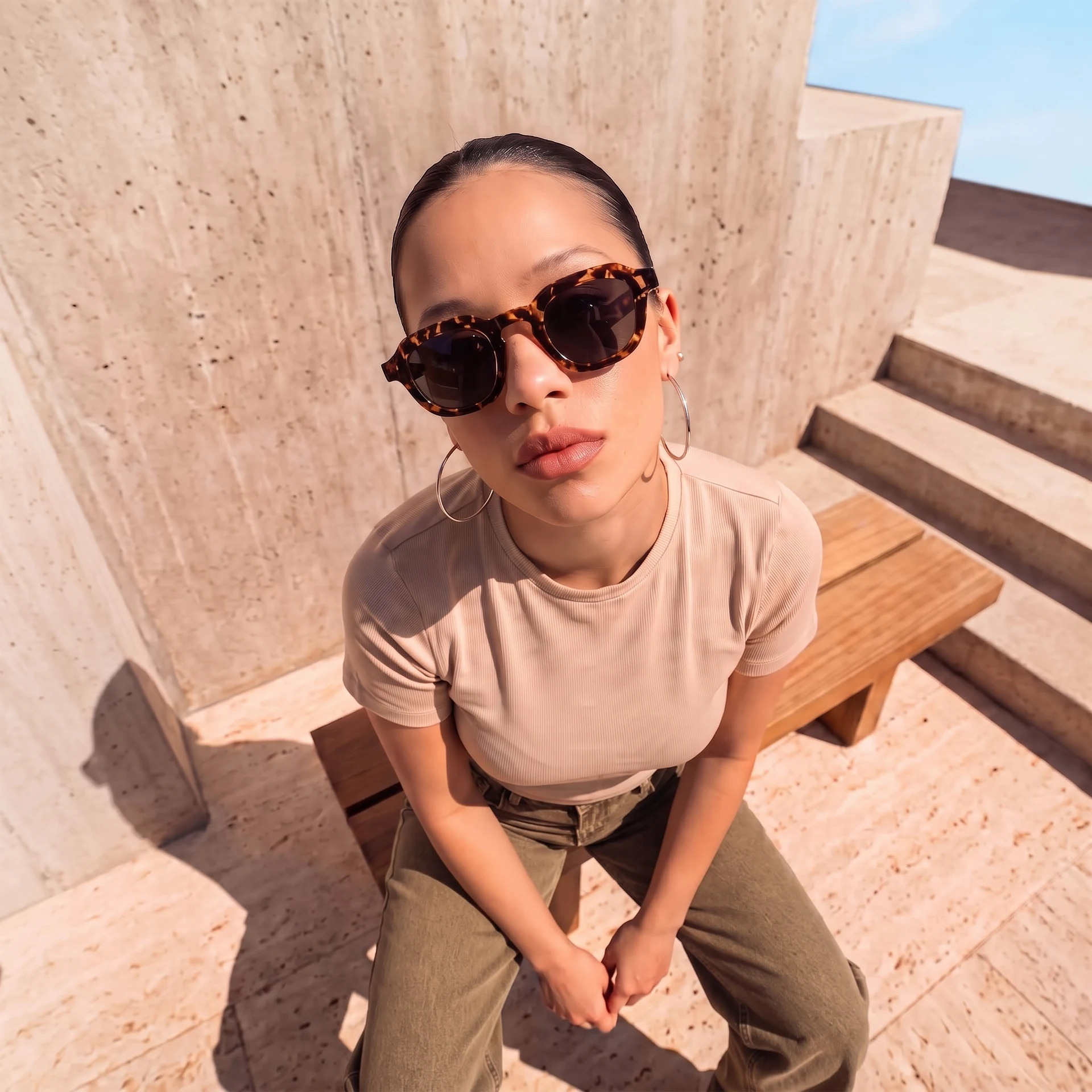 AI female model wearing dark Vello sunglasses, photographed from above